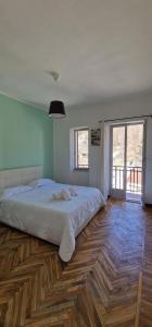 - une chambre avec un grand lit et du parquet dans l'établissement Hostsrevolution Pragelato, à Pragelato