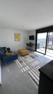 a living room with a blue chair and a couch at New Large STUDIO flat in Tel Aviv 47 in Tel Aviv
