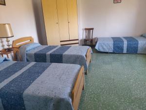 a hotel room with three beds and a chair at Casa Real in Serón