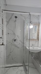 uma casa de banho com um chuveiro e um lavatório. em Vila Massimo em Eforie Nord