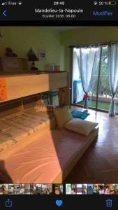 een foto van een slaapkamer met een bed in een kamer bij Appartement climatisé avec piscines proche mer in Mandelieu-la-Napoule