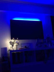 een blauwe kamer met een tv en een blauw licht bij Appartement climatisé avec piscines proche mer in Mandelieu-la-Napoule