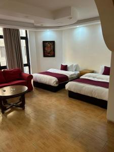 une chambre d'hôtel avec deux lits et un canapé dans l'établissement Red Carpet 2, à Amman
