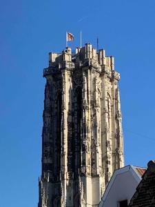 a tall tower with a flag on top of it at #2800ourhome 202 in Mechelen