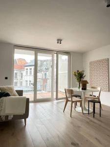 uma sala de estar com uma mesa e um sofá em #2800ourhome 202 em Mechelen