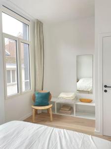 a bedroom with a bed and a chair and a window at #2800ourhome 202 in Mechelen