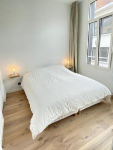 ein weißes Bett in einem Zimmer mit Fenster in der Unterkunft #2800ourhome 202 in Mechelen