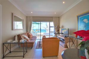 een woonkamer met een bank en een tafel bij Seashelles Self-catering Apartment in Durban