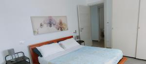 SoletoにあるAlma Casa Vacanzeのベッドルーム1室(ベッド1台付)が備わります。壁に絵が飾られています。