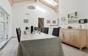 a kitchen and dining room with a table and chairs at Beautiful Home In Væggerløse With Sauna in Bøtø By
