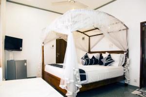a bedroom with a bed with a canopy at Suriya Arana in Negombo