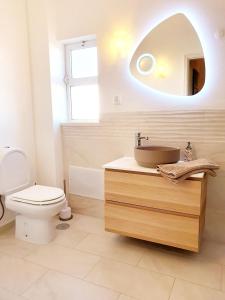 een badkamer met een wastafel, een toilet en een spiegel bij Casa Cristal in Lagos