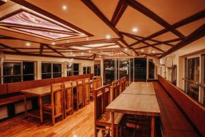 una sala da pranzo con tavoli e sedie in legno di Venice Premium Houseboats Alleppey a Alleppey Altre 73 foto