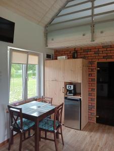 eine Küche mit einem Tisch und Stühlen im Zimmer in der Unterkunft Domki na Wzgórzu - Rospuda - Domek z sauną in Filipów