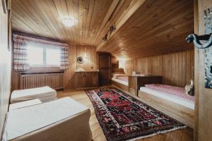 アヴェレンゴにあるChalet Magdalenaのベッド2台とラグ付きの小さな部屋です。