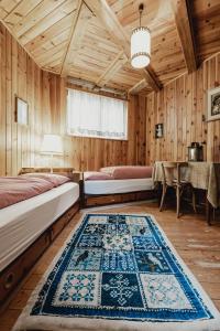 アヴェレンゴにあるChalet Magdalenaのベッド2台とラグが備わる客室です。
