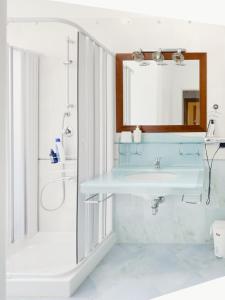 bagno con lavandino e specchio di Gravina suite Apartment a Gravina in Puglia