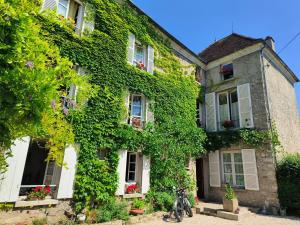 a house covered in ivy with a bike parked in front at Le Grand Barrois in Crécy-la-Chapelle