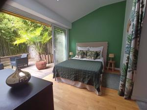 Schlafzimmer mit einem Bett und einer Glasschiebetür in der Unterkunft Les Suites Angevines in Angers