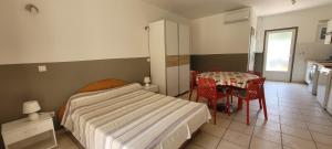 1 dormitorio con 1 cama y 1 mesa con sillas en Villa Maghjo Calvi Corsica, en Calvi