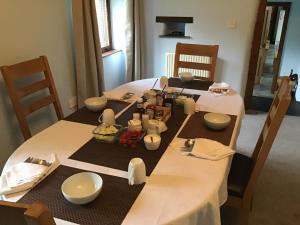 a dining room table with a table set with food at Owletts Barn B&B in Bodmin