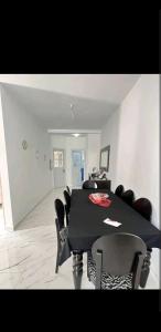 a dining room with a black table and chairs at Chez Sarah in Beni Khiar