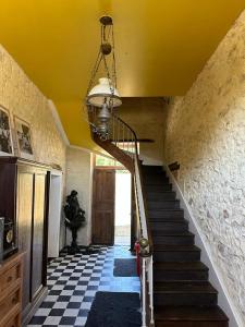 a staircase in a house with a yellow ceiling at Ancien relais de chasse à 35 min du Circuit 24h du Mans in Le Lude