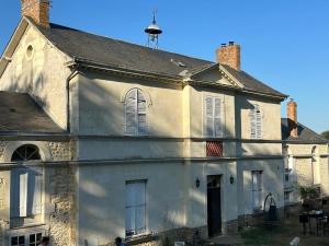an old white building with windows and a roof at Ancien relais de chasse à 35 min du Circuit 24h du Mans in Le Lude