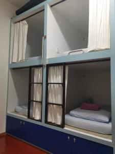 a bunk bed in a room with a small bed in it at Sojourn Beds & Cafe in Taiping