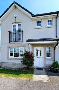 een wit bakstenen huis met een witte deur bij 26 Woodgrove Drive in Inverness