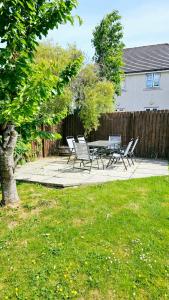a patio with a table and chairs in a yard at 26 Woodgrove Drive in Inverness