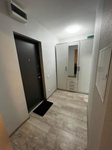 korytarz z czarnymi drzwiami i podłogą wyłożoną kafelkami w obiekcie Lovely Stay in Siauliai w Szawlach