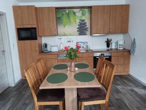 une cuisine avec une table avec un vase de fleurs dessus dans l'établissement Ferienwohnung am Vareler Hafen/ Nordsee, à Varel