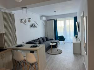 a living room with a couch and a table at Apartament Hera Mamaia Nord in Năvodari