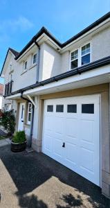 a white garage door on the side of a house at 26 Woodgrove Drive in Inverness