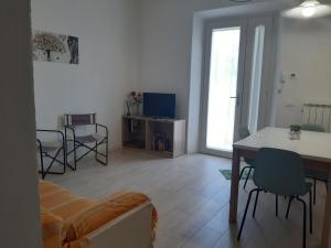 een woonkamer met een bank en een tafel en stoelen bij Casa Dino in Rosignano Solvay