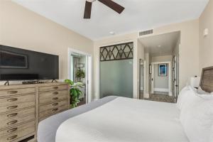a bedroom with a white bed and a dresser at 'Cloud 10' A Luxury Downtown Condo with Panoramic City and Mountain Views at Arras Vacation Rentals in Asheville