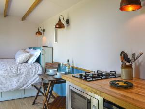 a room with a bed and a kitchen with a table at Wildflower View in Lowthorpe