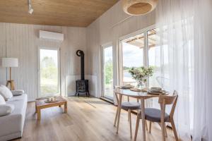 a living room with a table and a fireplace at Pineplace twins Smilga in Žaugėdai
