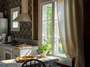 cocina con mesa y ventana grande en Punainen pihatorppa Hauholla en Alvettula