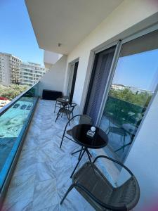 a balcony with chairs and tables on a building at Apartament Hera Mamaia Nord in Năvodari
