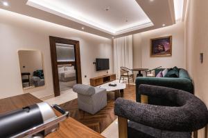 فندق ترى في الرياض: غرفة معيشة بها أريكة وكراسي وتلفزيون