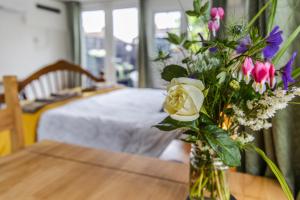 eine Vase voller Blumen auf einem Tisch in der Unterkunft Cozy Garden Studio in Williton
