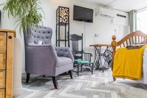 a living room with a chair and a tv at Cozy Garden Studio in Williton