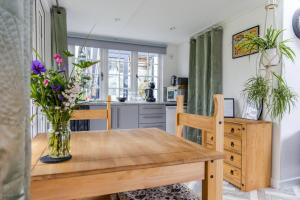a dining room table with a vase of flowers on it at Cozy Garden Studio in Williton