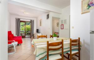 een eetkamer met een tafel en een rode bank bij 2 Bedroom Lovely Apartment In Pinezici in Pinezici