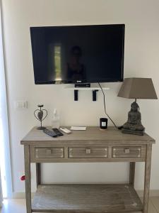 einen TV an einer Wand mit einem Tisch und einer Lampe in der Unterkunft Casa Vacanze Randelli in Ameglia