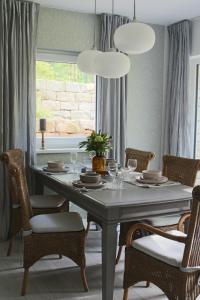 a dining room with a table with chairs and lights at Moderne Wohnung im skandinavischen Stil am Waldrand in Schwielowsee