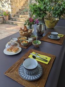 a table with plates of food on top at Le Clos sous le chemin in Seillans