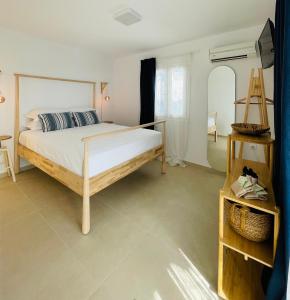a bedroom with a large bed and a table at Mykonian Starling - Town n' Sunset View Apartment in Mikonos